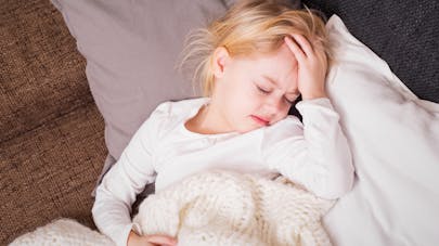 enfant se touchant la tête
