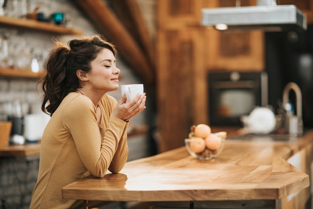 mujer oliendo cafe
