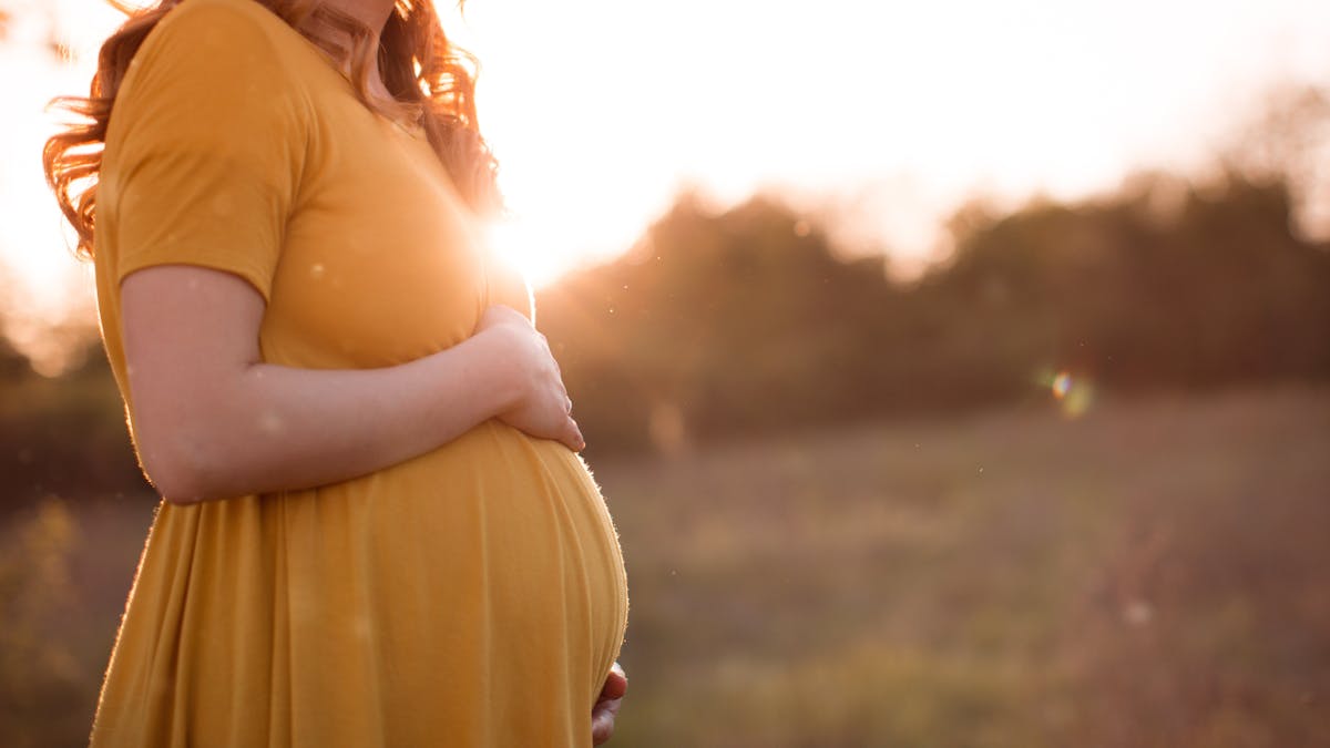Femme enceinte dans une robe orange.