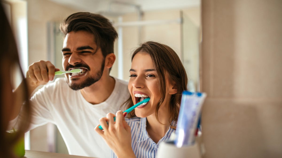 homme et femme se brossant les dents