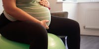Femme enceinte sur un ballon de grossesse.