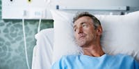 Un homme sur un lit d'hôpital attend son opération