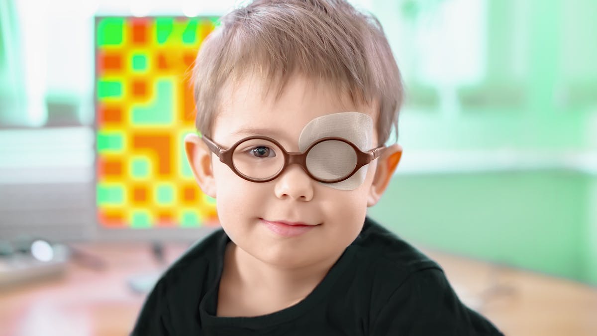 Petite garçon portant une paire de lunettes et un cache-oeil pour prévenir l'amblyopie.