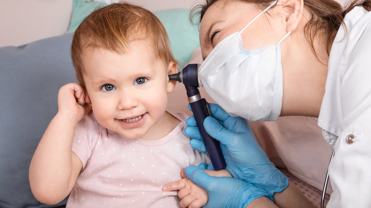 Médecin qui examine l'oreille d'une petite fille