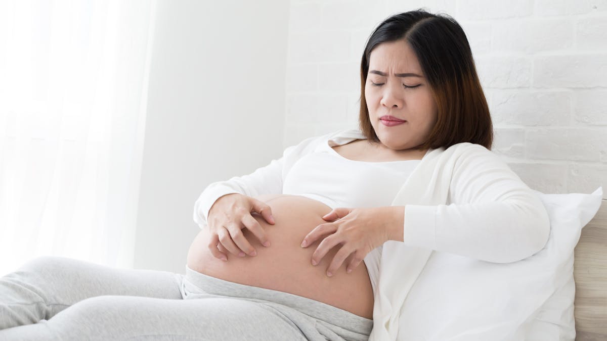 Femme enceinte qui se gratte le ventre.