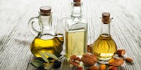 bouteilles d'huiles et fruits oléagineux : noix, amandes