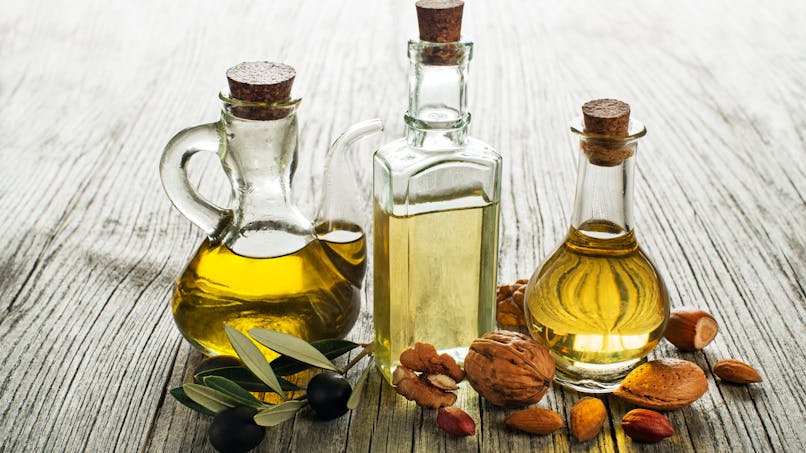 bouteilles d'huiles et fruits oléagineux : noix, amandes