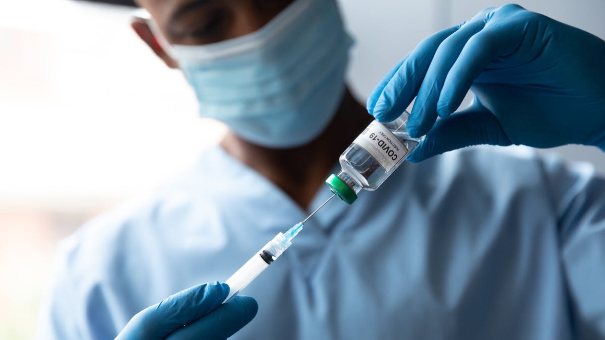 Un infirmier prépare une dose de vaccin
