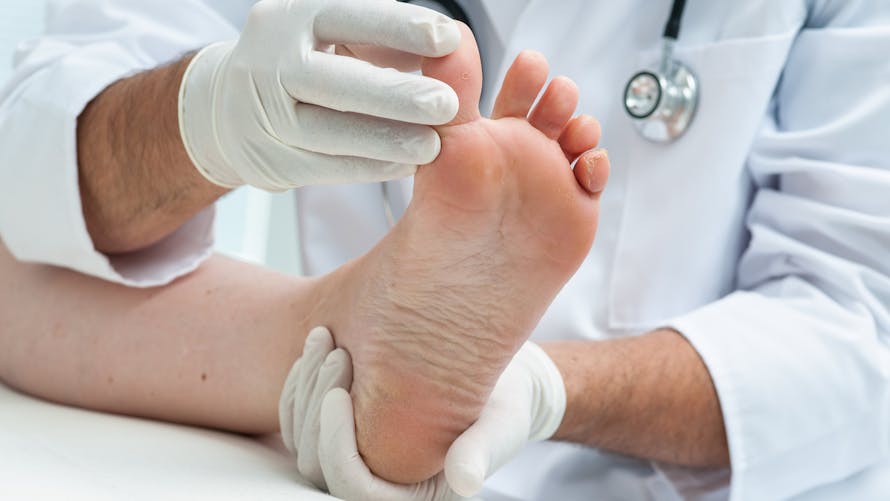 Podologue qui examine les ongles de pieds