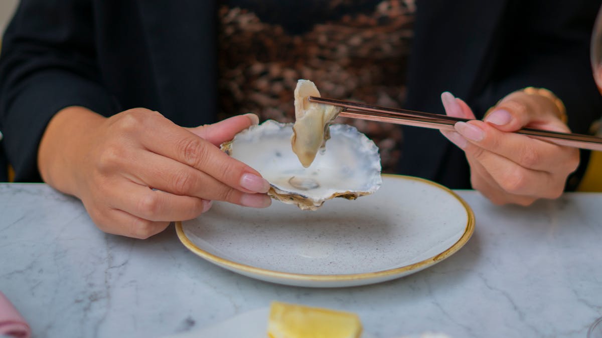 Une femme mange des huîtres