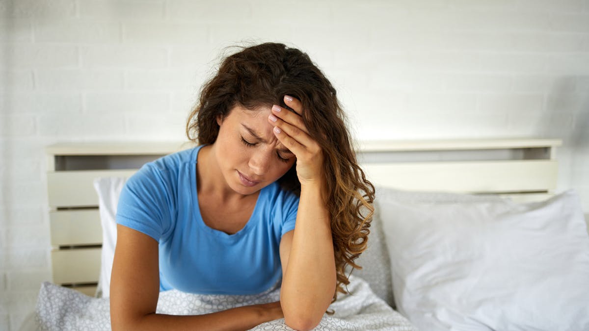 Une femme se réveille avec un mal de tête