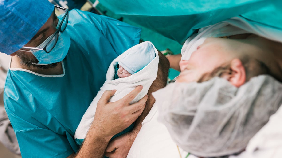 Médecin présentant un nouveau-né à sa mère.