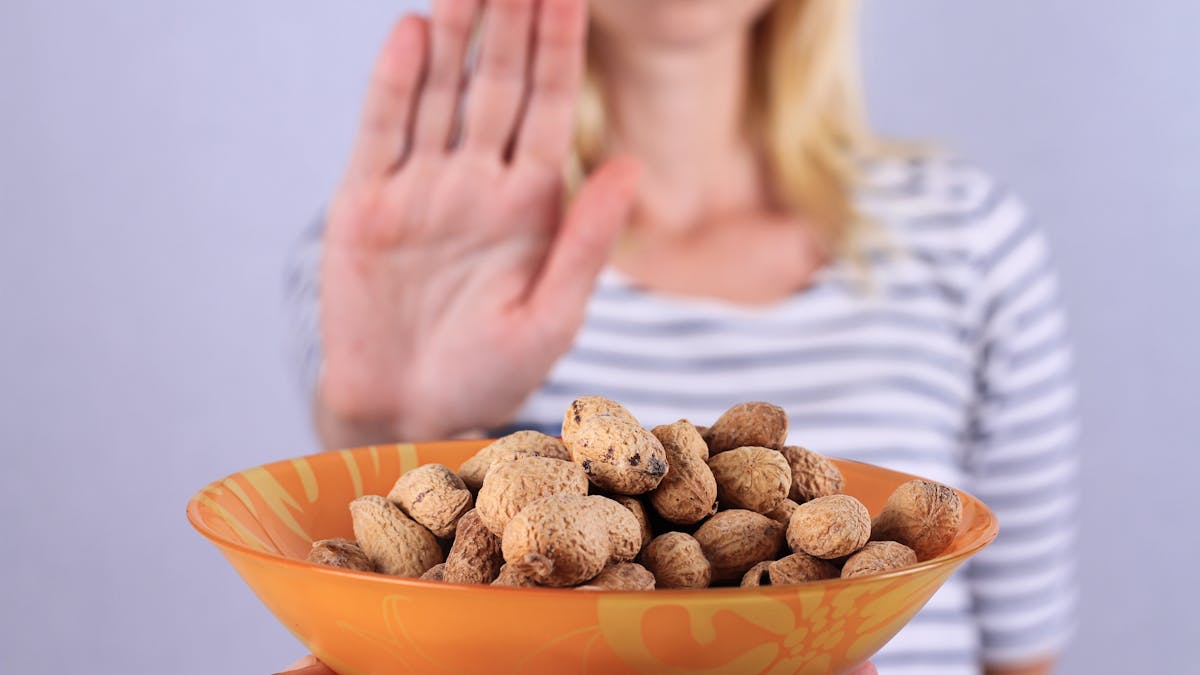 Femme qui refuse de manger des cacahuètes, allergie alimentaire