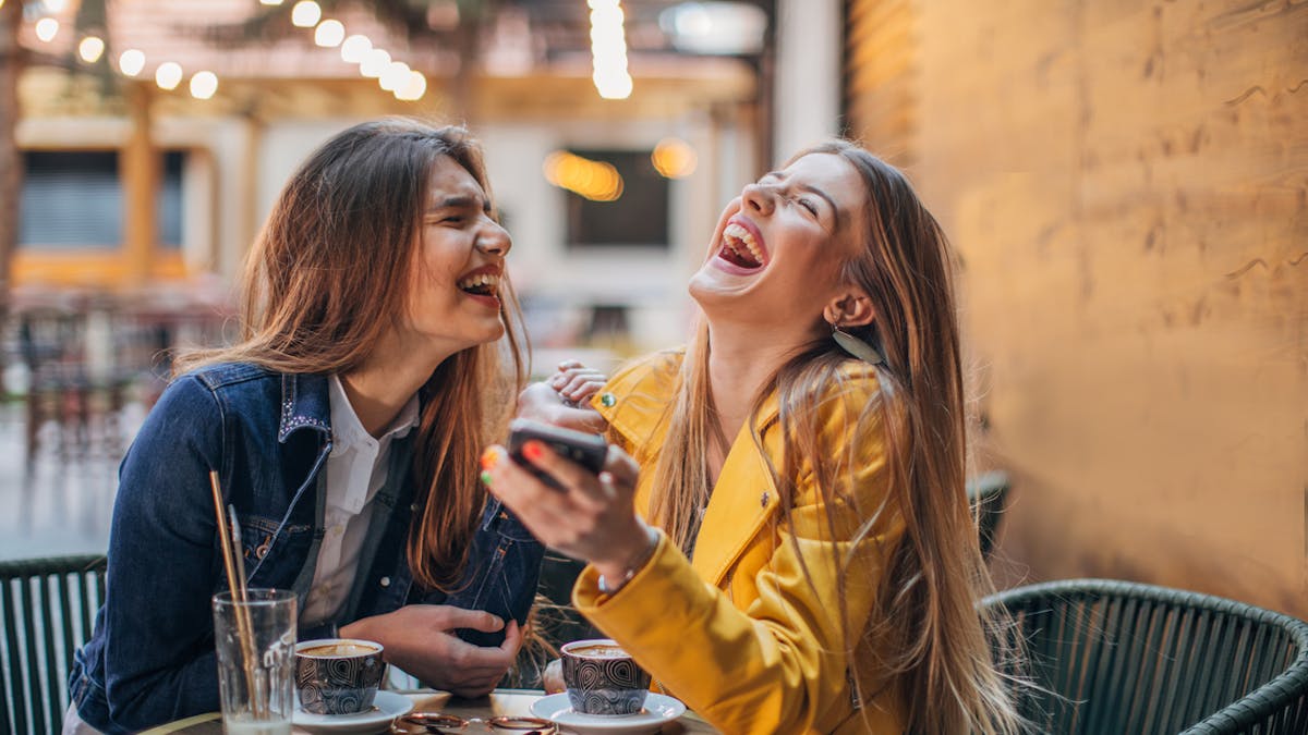 Deux jeunes femmes en train de rire dans un restaurant