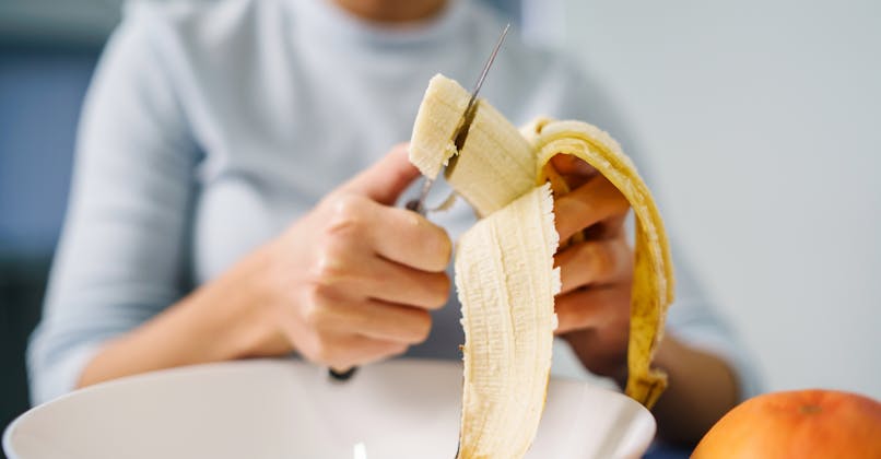 Une femme mange des bananes au petit-déjeuner