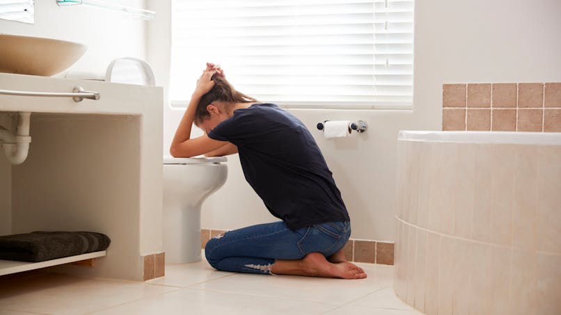 Une femme vomit dans sa salle de bain