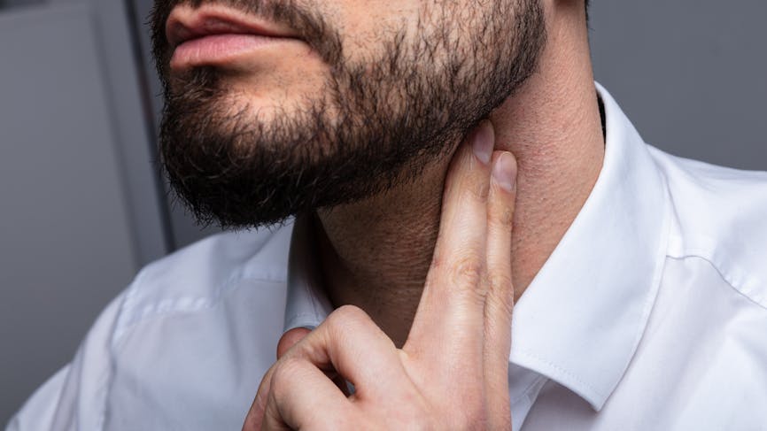 Homme avec doigt sur le cou pour contrôler son débit sanguin