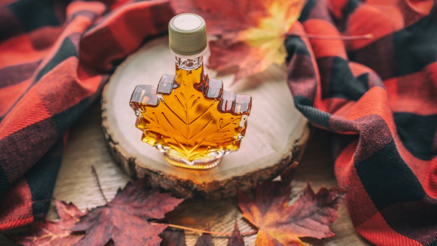 Sirop d'érable dans un flacon en forme de feuille d'érable, automne